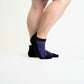 A person wearing purple ankle socks