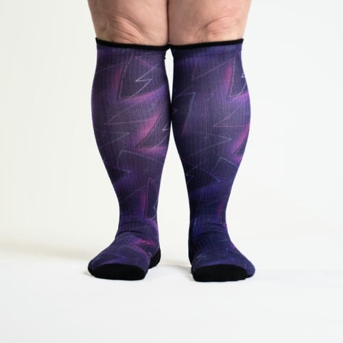 A person standing in purple compression socks