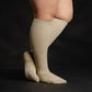 A person wearing knee-high tan socks