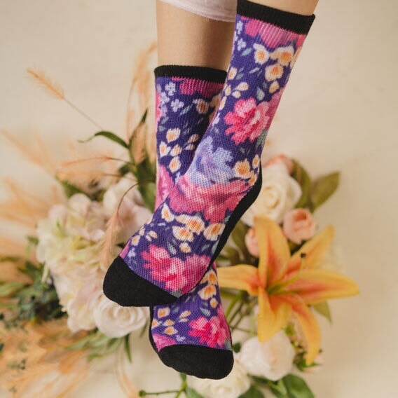 A person wearing floral non-binding crew socks