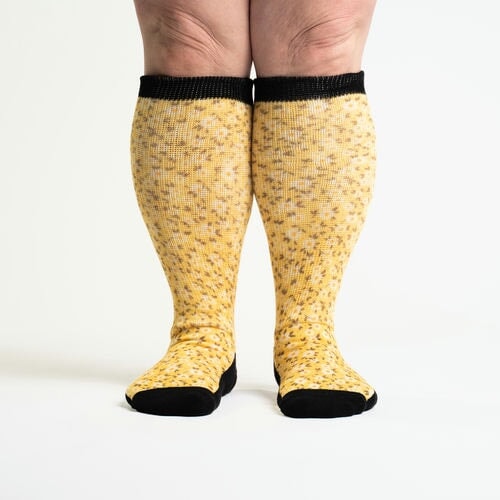 A person wearing knee-high yellow flower socks