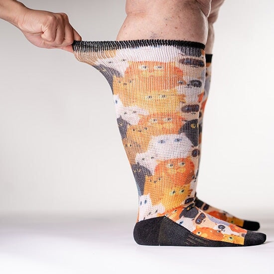 A person wearing stretchy cat pattern diabetic socks