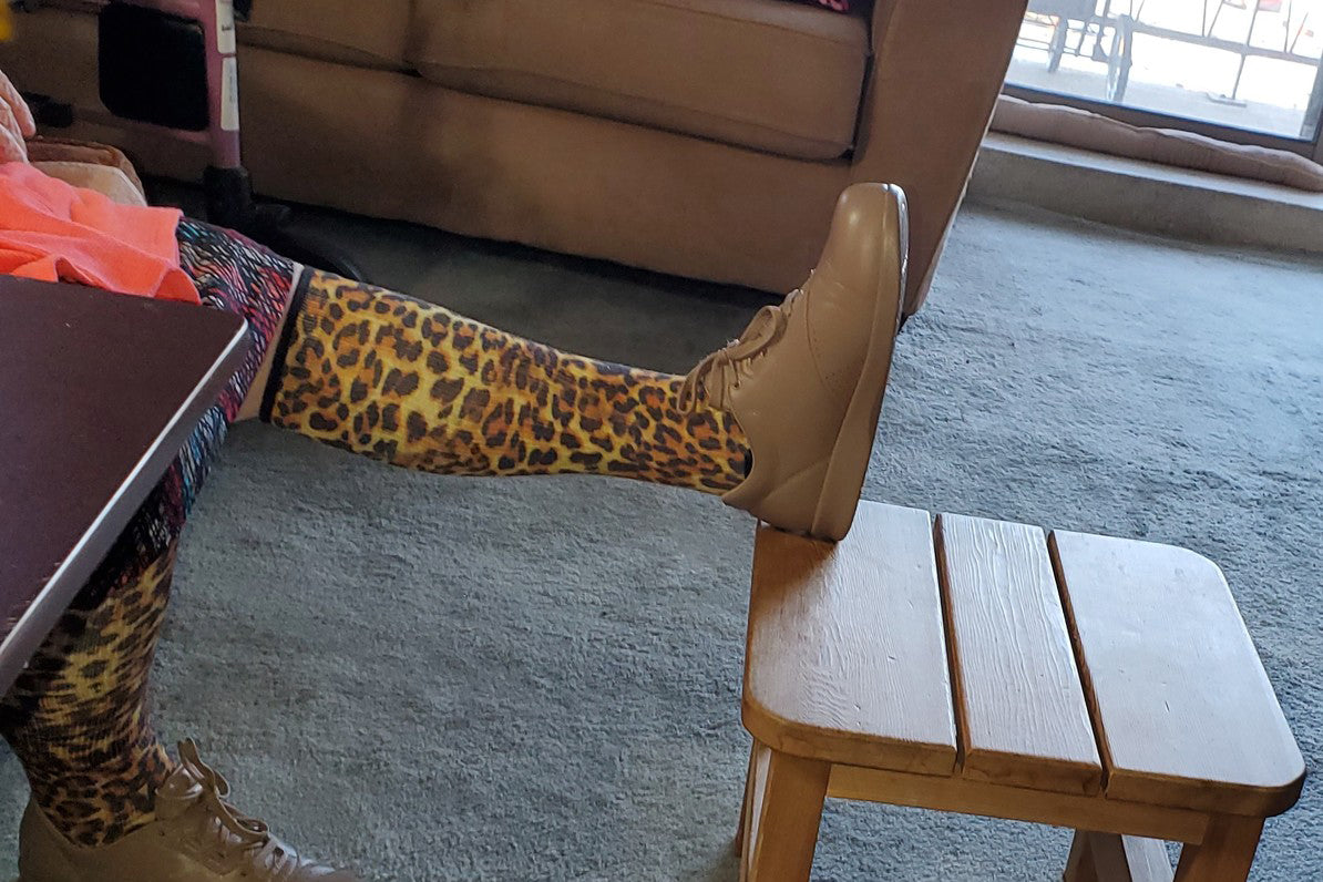 Leg on the table showcasing cheetah pattern compression socks