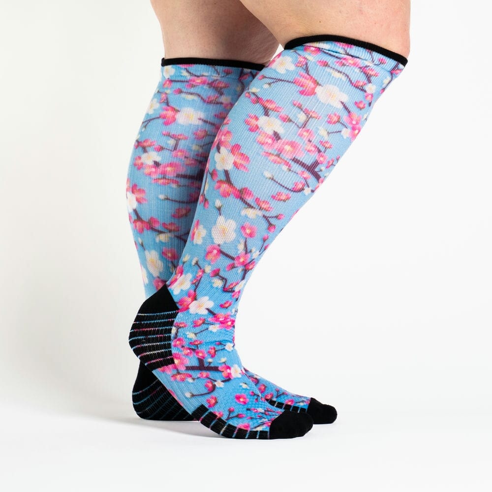 A person wearing cherry blossom print compression socks