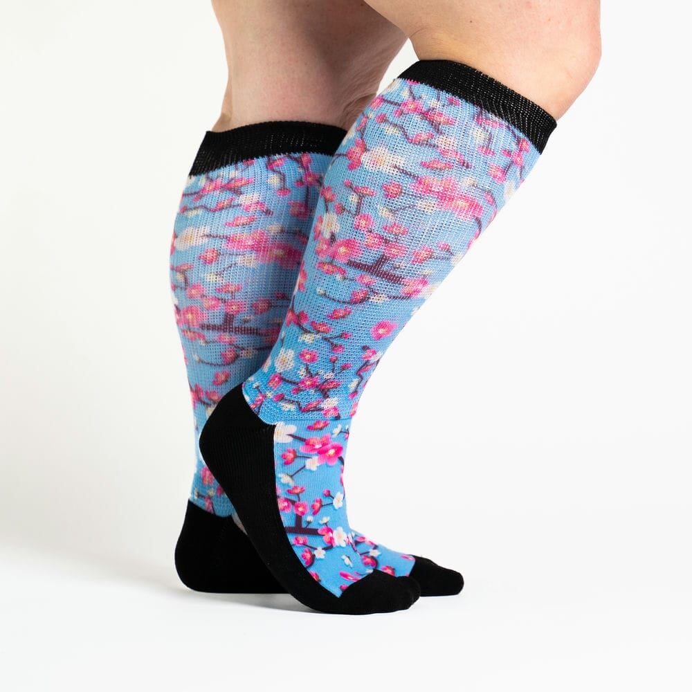 A person wearing knee-high cherry blossom socks