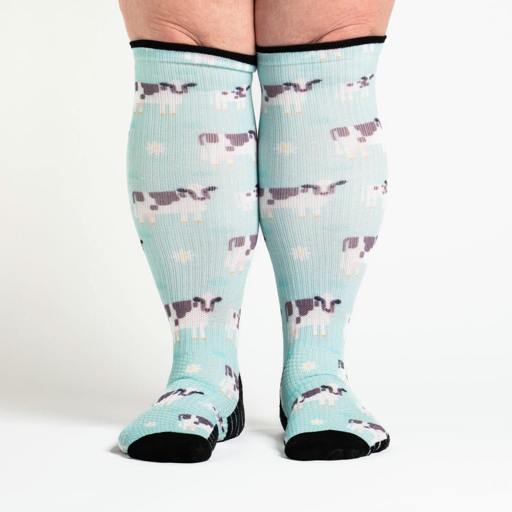 A person wearing cow print compression socks