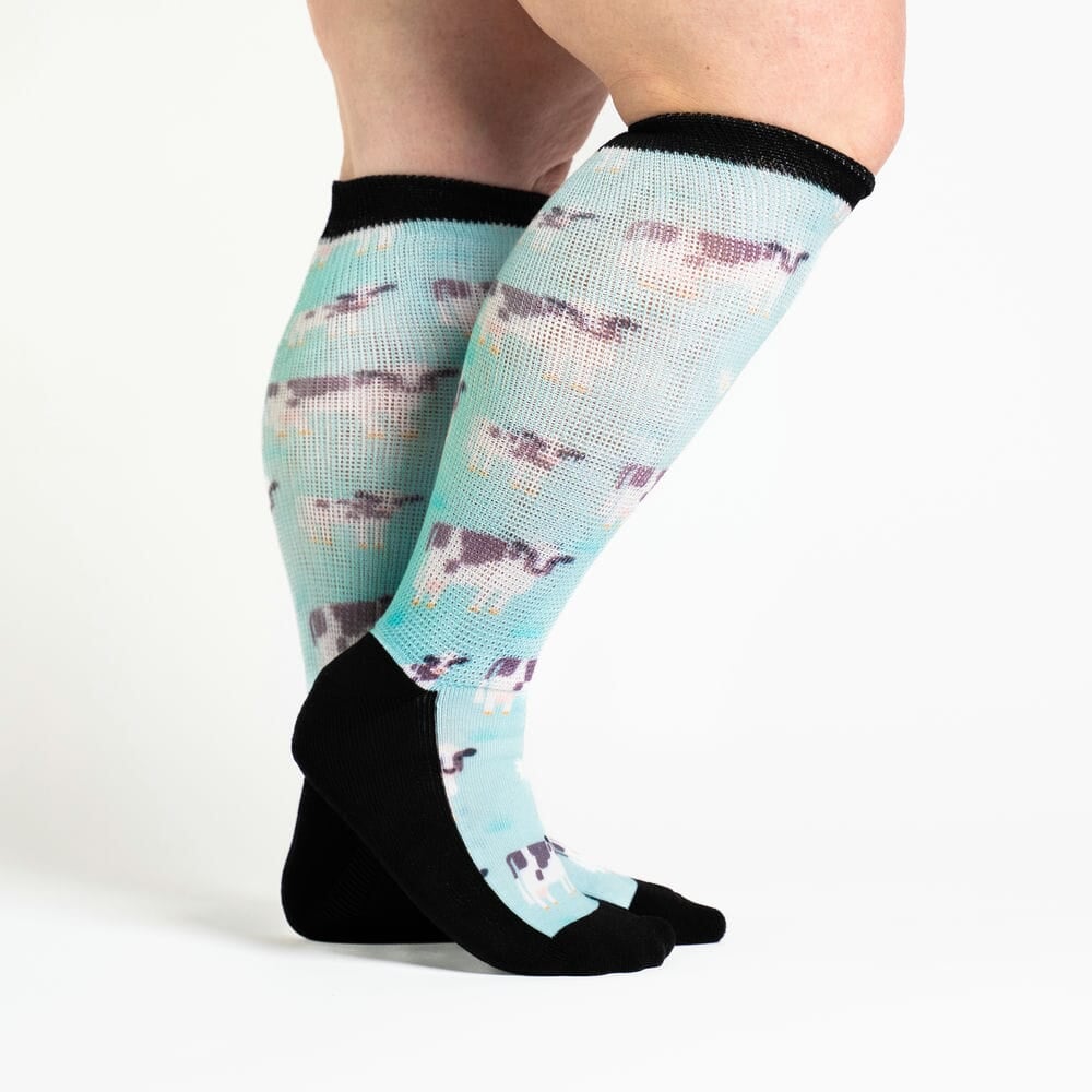 A person wearing knee-high cow socks
