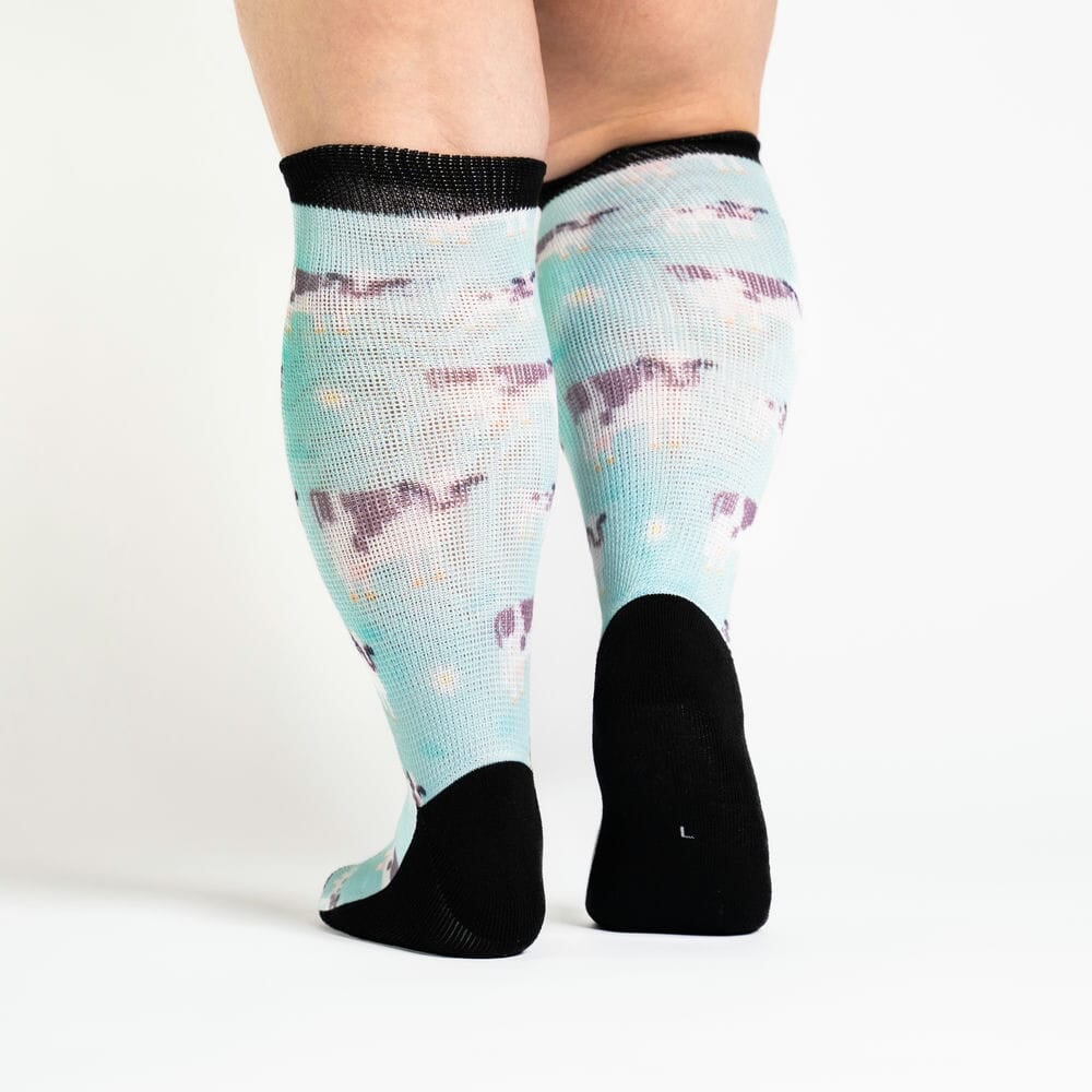 A person walking in knee-high cow socks